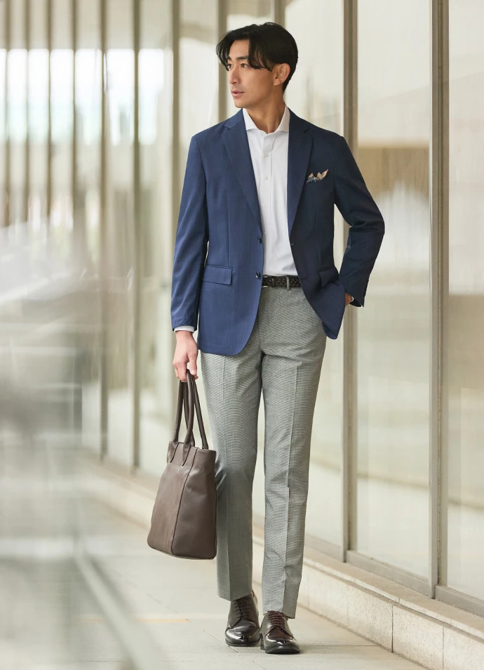 ネイビーのジャケットと白×黒の千鳥柄のパンツを合わせたセパレートスタイルの写真