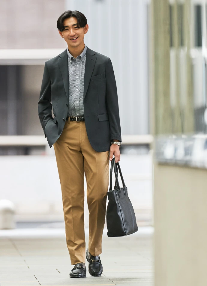 チャコールグレーのジャケットとベージュの綿パンツを合わせたセパレートスタイルの写真